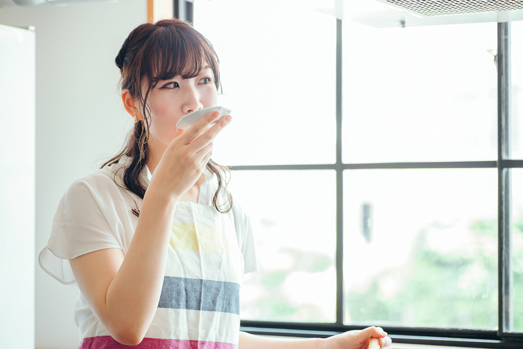 お出汁の味見をする女性